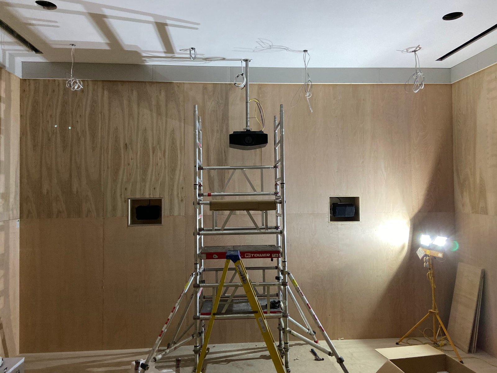 Building a dedicated cinema, hanging a projector on a custom made bracket.